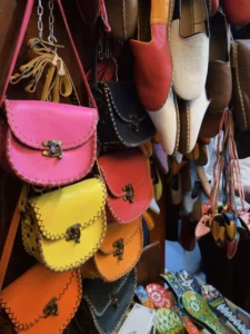 Bolsas de couro coloridas penduradas na parede de uma loja de artigos de couro