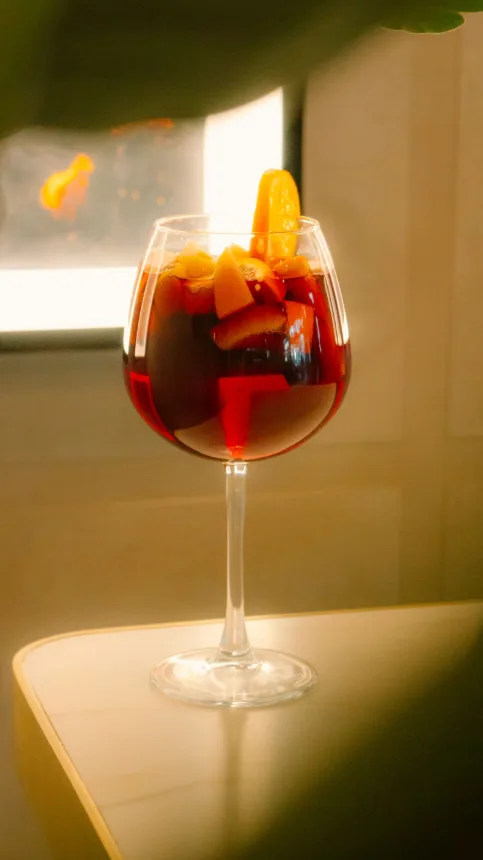 Taca de sangria de vinho tinto com pedacos de fruta