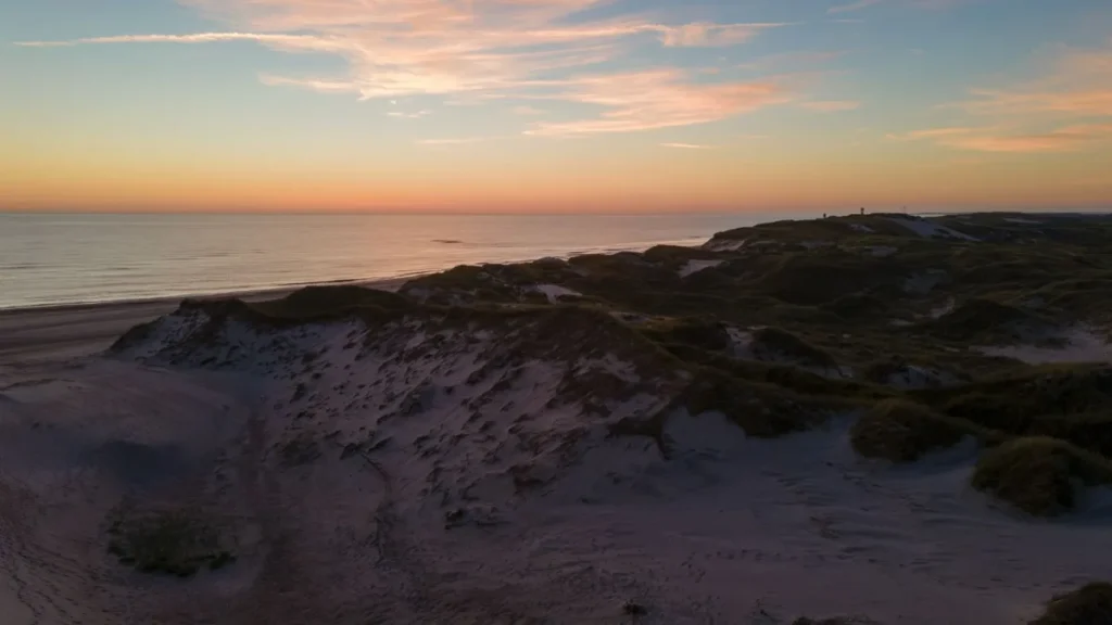 Costa ao entardecer com o céu ainda claro sobre o mar