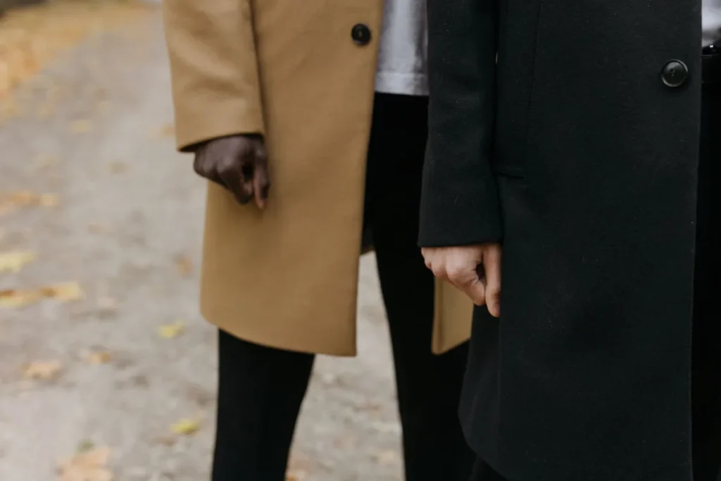 Duas pessoas de casaco caminhando lado a lado em dia frio