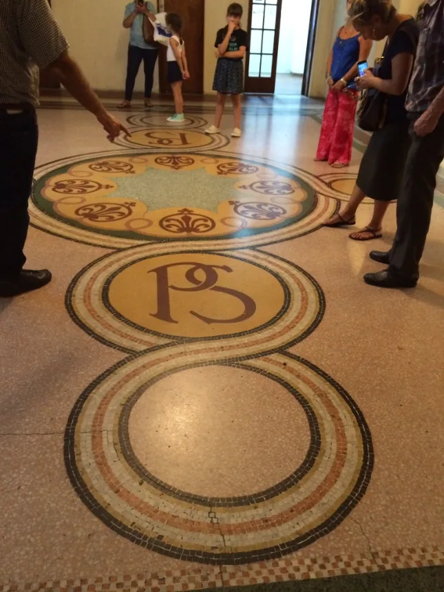 Visitantes observando o piso de mosaico durante a visita guiada ao Palacio Salvo