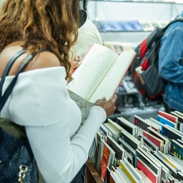 Visitantes entre estantes na Feria Internacional del Libro de Montevideo